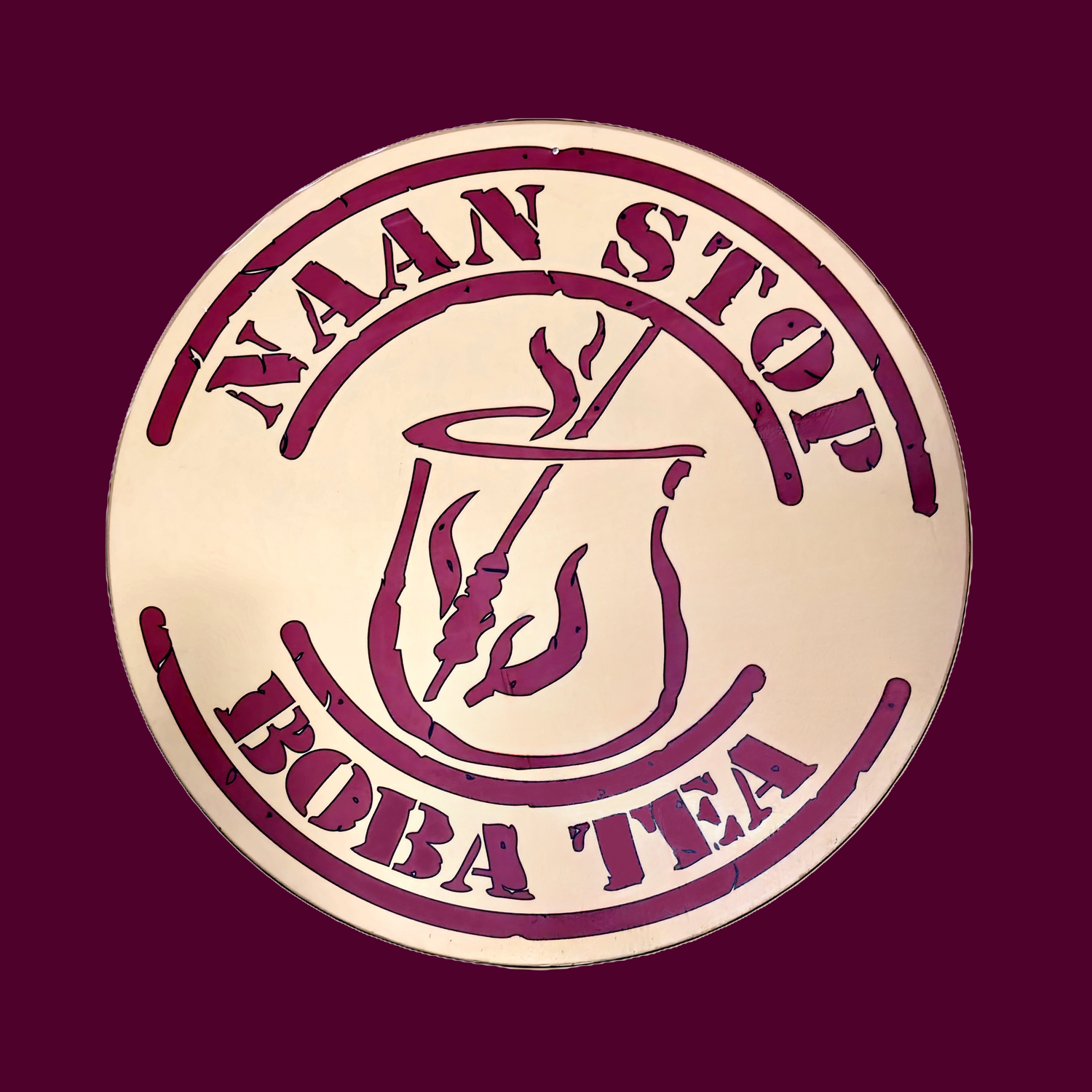 naan stop boba tea text in maroon within a beige circle and maroon background
